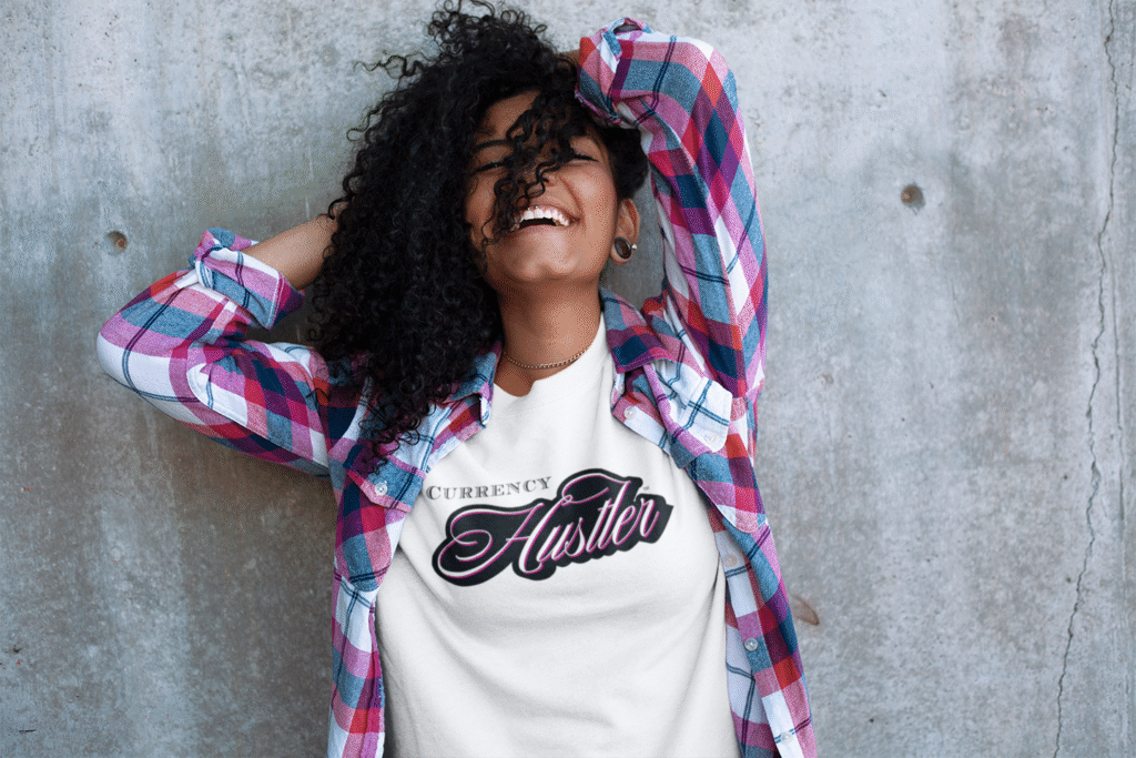 Front view of a happy young woman wearing the Currency Hustler T-shirt by Mastuhree, featuring a bold graphic, premium cotton fabric, and confident streetwear style.