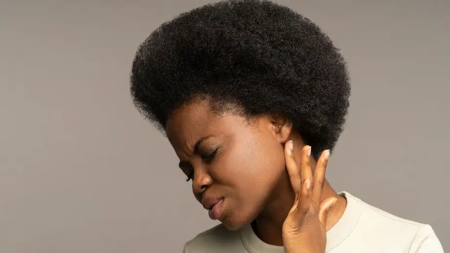 Woman looking concerned while holding her stomach — potential overlooked cancer symptom.