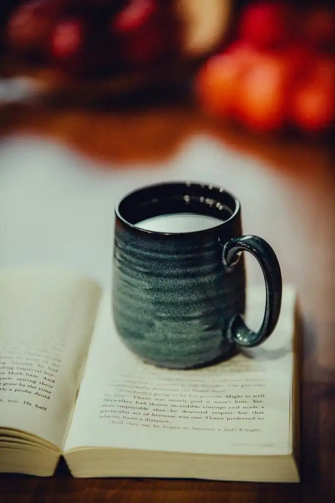 Cup of tea and open book representing self-care and mental health relaxation time.