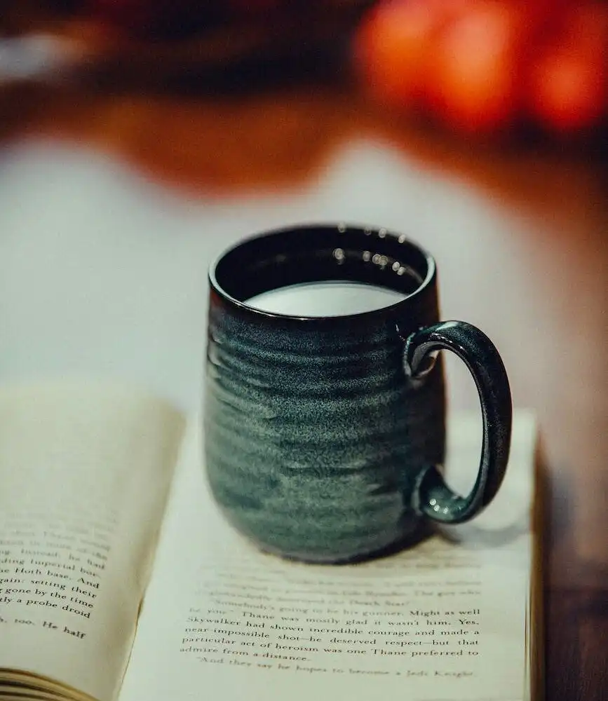 Cup of tea and open book representing self-care and mental health relaxation time.