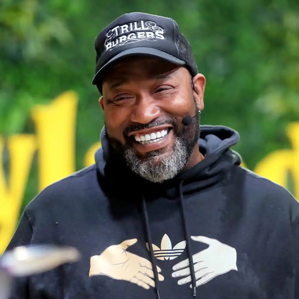 Bun B serving burgers at Trill Burgers in Houston, with fans lining up during Honeyland Festival for Trill OG and Vegan OG combos.