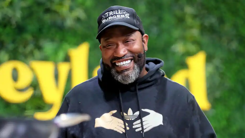Bun B serving burgers at Trill Burgers in Houston, with fans lining up during Honeyland Festival for Trill OG and Vegan OG combos.