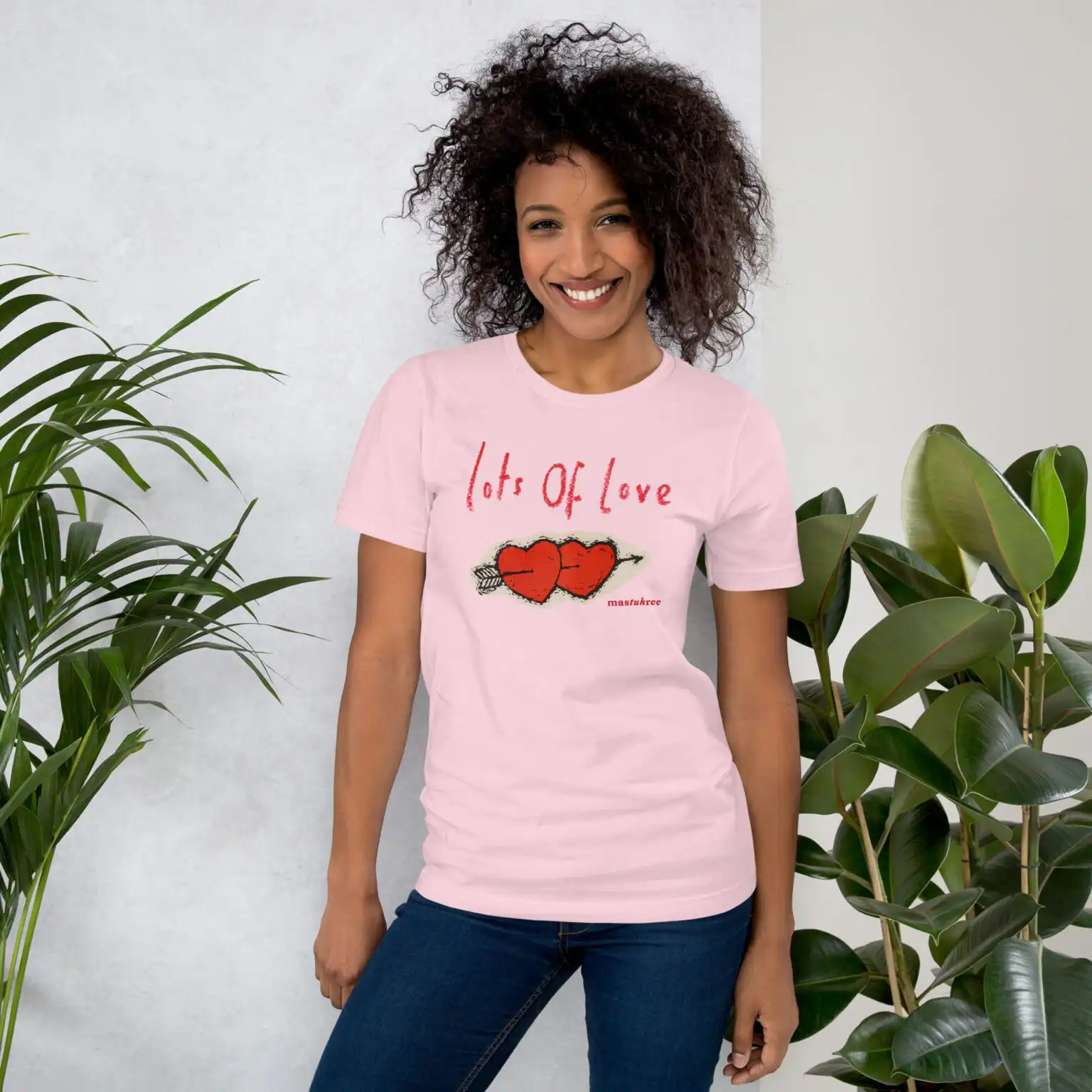 Pretty girl wearing a Love T-Shirt in a casual, stylish outfit. Lots of Love T-Shirt with heart graphic promoting kindness and positivity