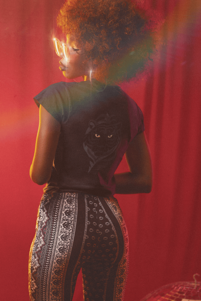 Black woman wearing black tiger graphic t-shirt with bold back print.