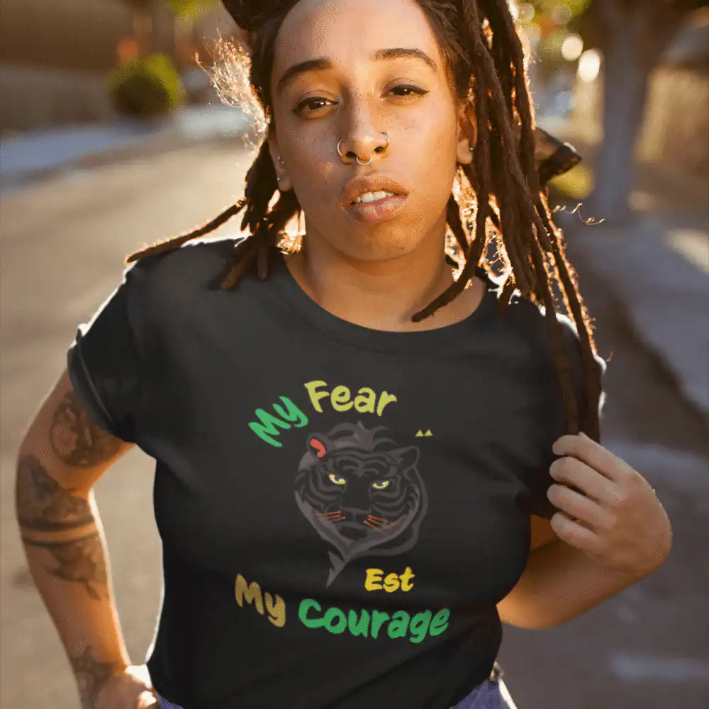 Person wearing “My Fear Est My Courage” t-shirt in minimalist black-and-white design, inspired by Bob Marley’s message of strength