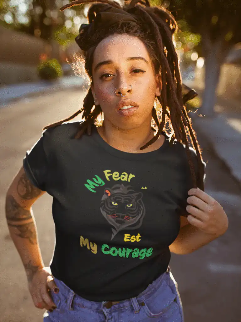 Person wearing “My Fear Est My Courage” t-shirt in minimalist black-and-white design, inspired by Bob Marley’s message of strength