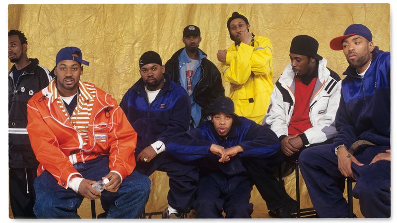 Wu-Tang Clan 1990s hip hop fashion wearing oversized hoodies, baggy jeans, Timberland boots, and bold streetwear style