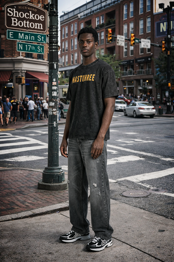 Young man wearing a Mastuhree white wash T-shirt standing on a busy street corner in Shockoe Bottom, downtown Richmond, Virginia, urban streetwear style