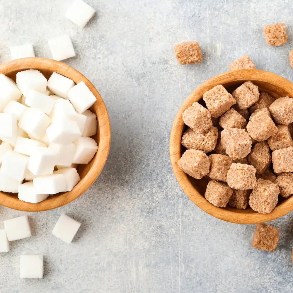 Coffee cup with artificial sweetener packets next to raw sugar, representing the comparison between sucralose, aspartame, and natural sugar