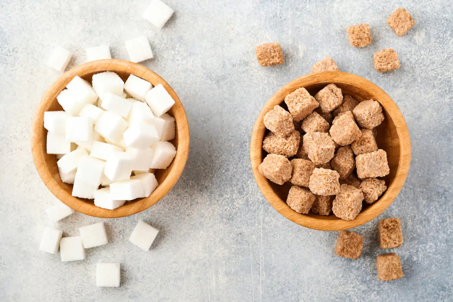 Coffee cup with artificial sweetener packets next to raw sugar, representing the comparison between sucralose, aspartame, and natural sugar