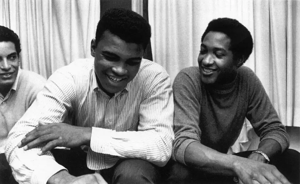 Sam Cooke and Muhammad Ali smiling together in a candid moment