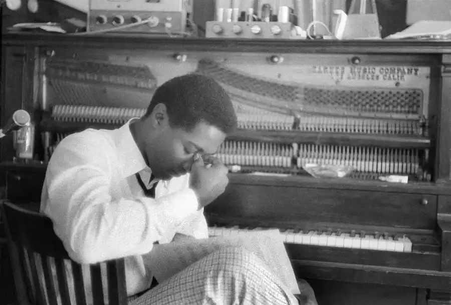 Sam Cooke seated at a piano composing music