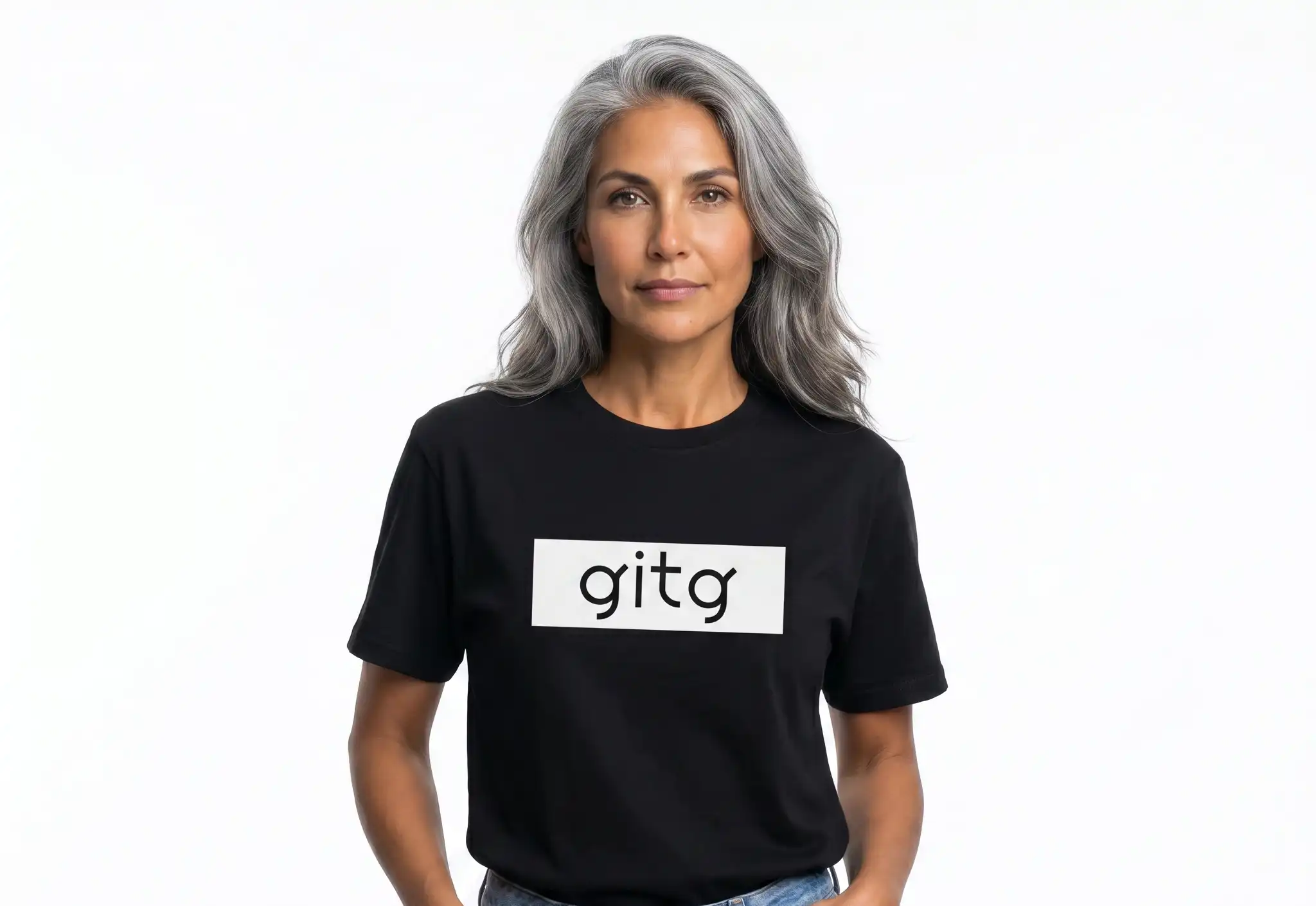 Female model wearing the Mastuhree Brand God Is The Greatest graphic t-shirt with light wash denim jeans and white sneakers, representing faith, gratitude, self-expression, and inspirational streetwear fashion.