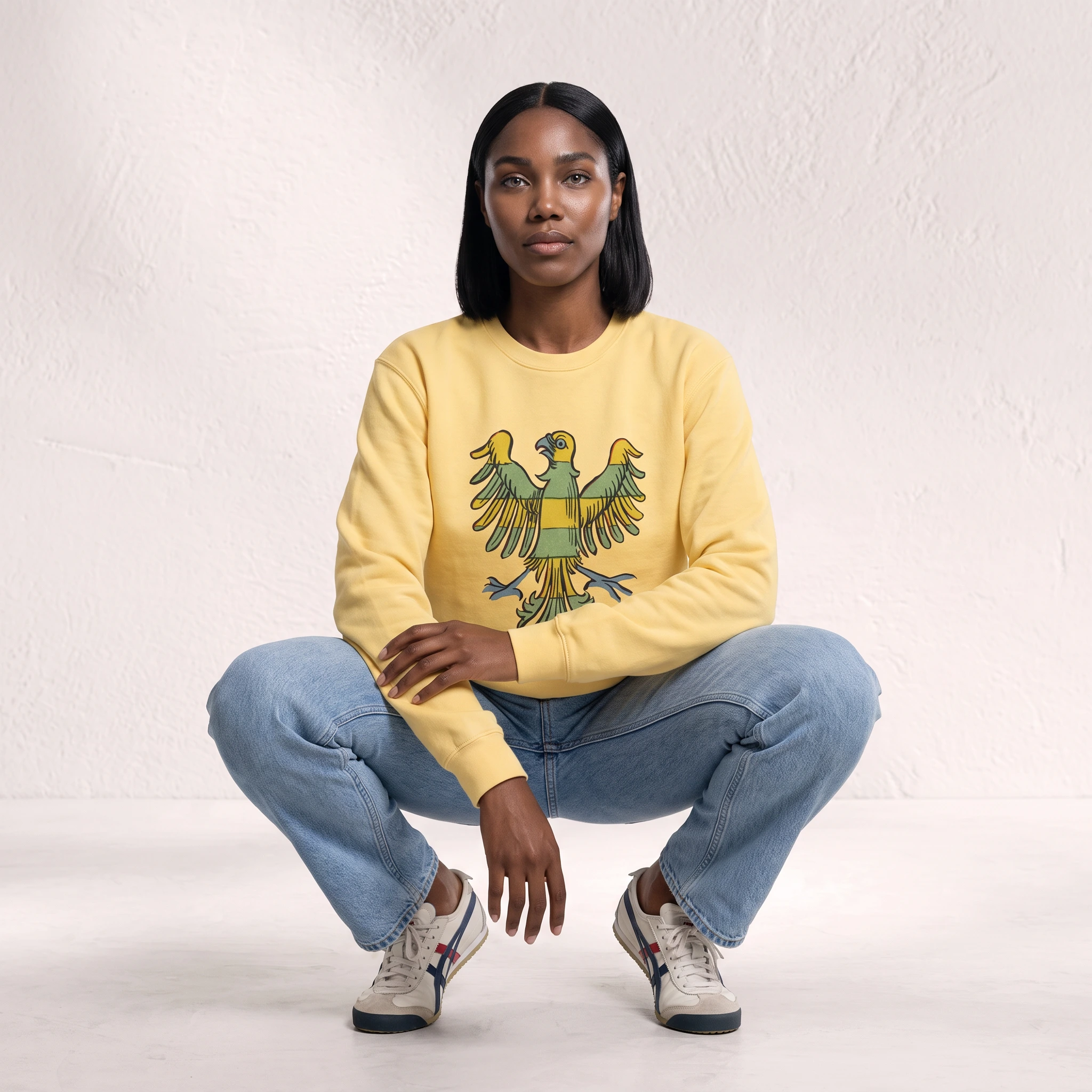 Woman wearing the Butter Freedom Bird graphic sweatshirt with blue jeans and sneakers